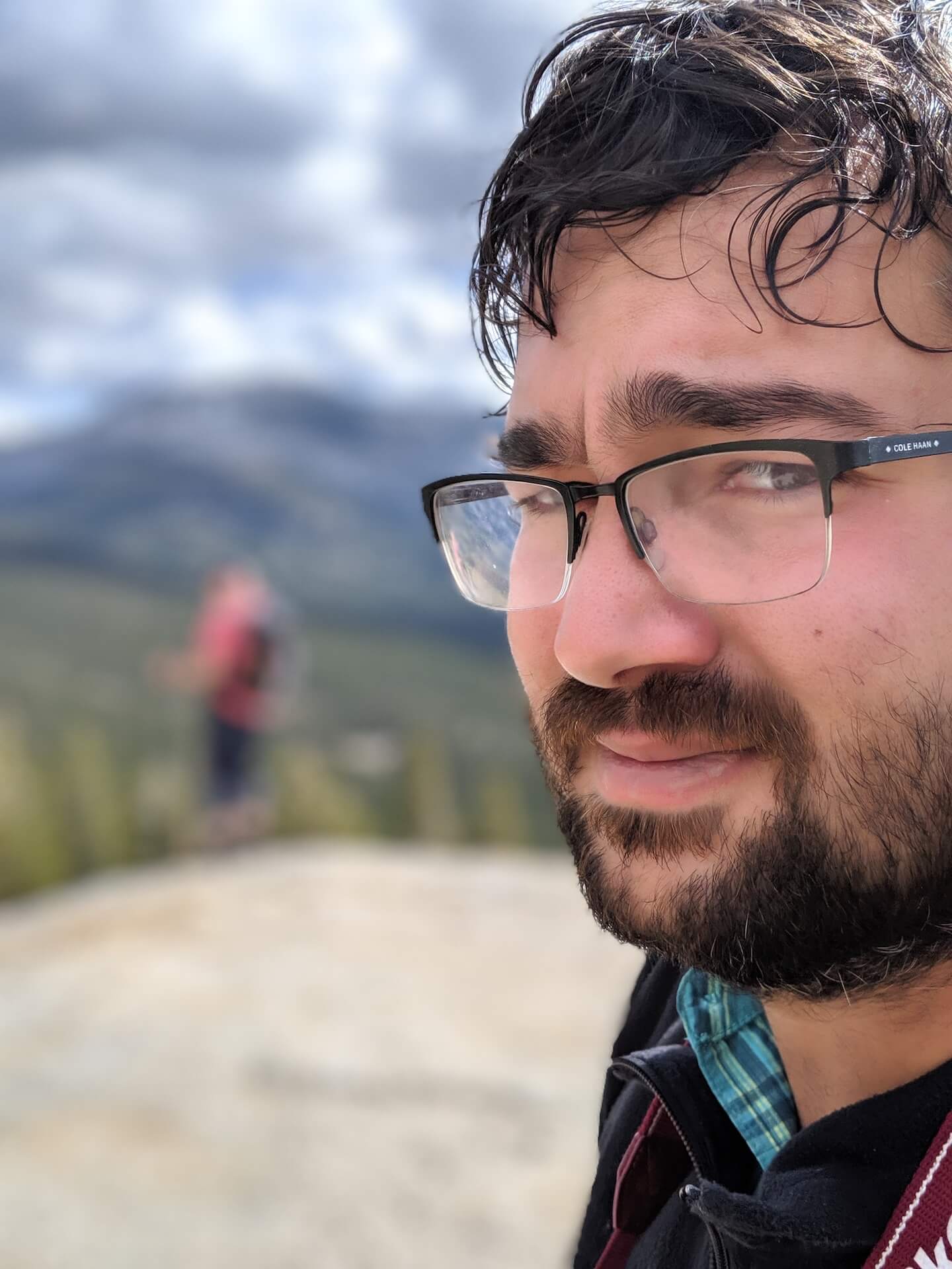 Closeup image of Tyler's face, with mountains out of focus in the background. He's very handsome